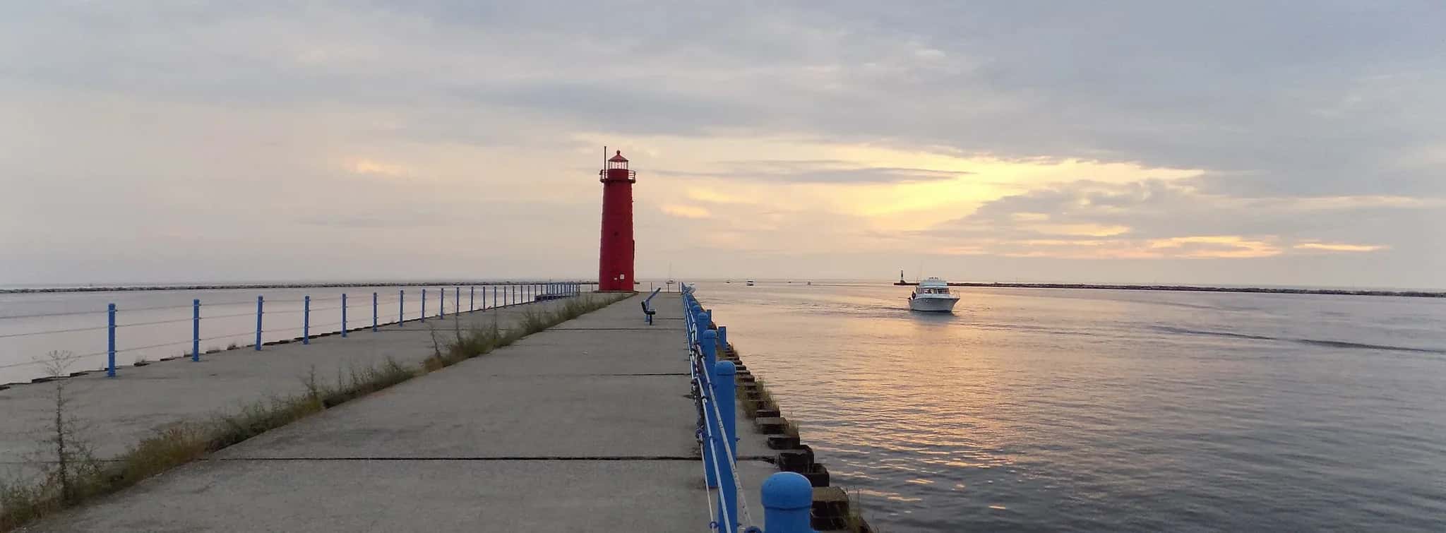 Muskegon pier and red lighthouse on the channel to Lake Michigan at sunset