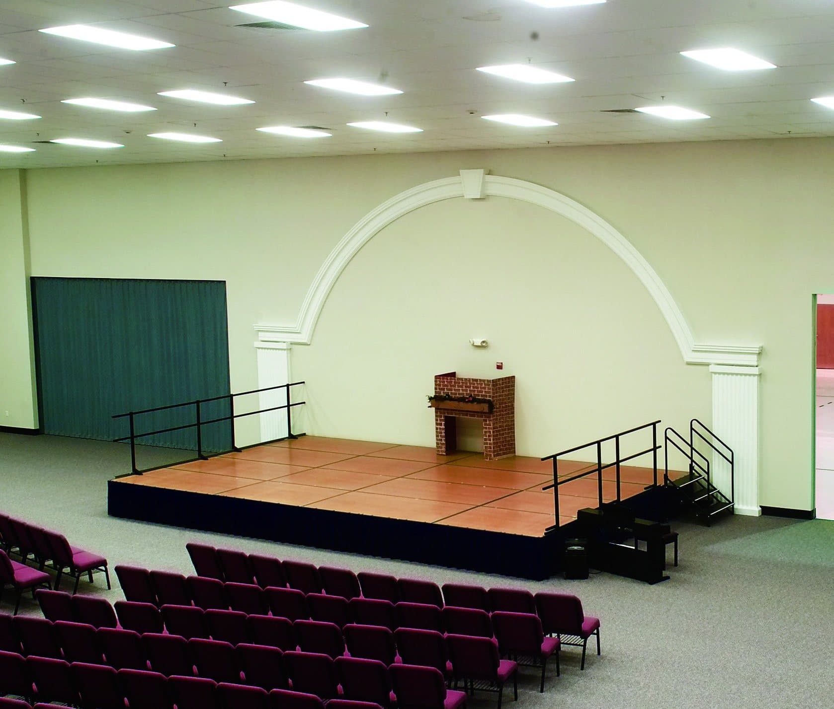 Modernfold accordion partition closed across a fellowship hall stage