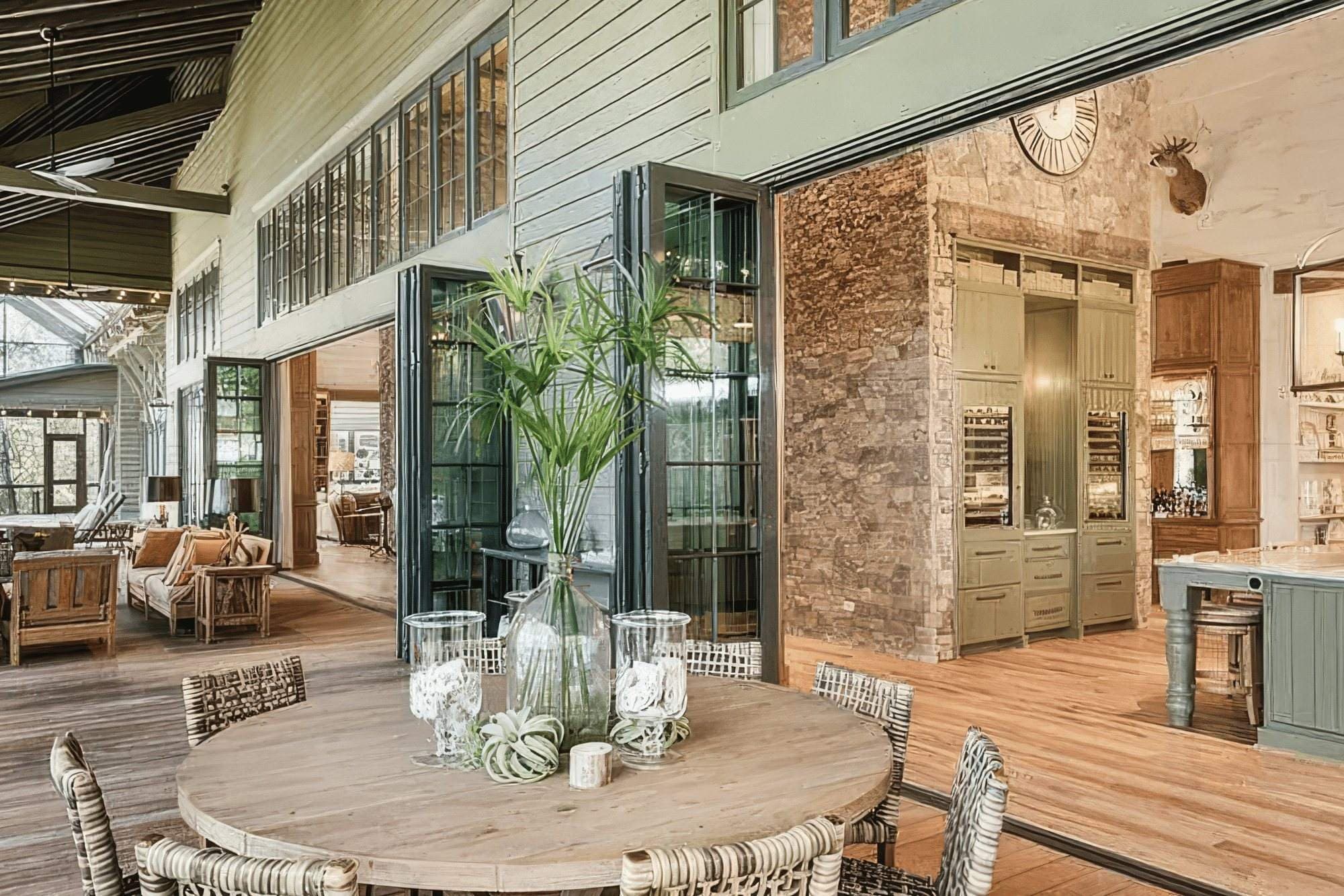 Euro-Wall Vista Fold folding glass wall open between a large kitchen and a covered outdoor dining porch