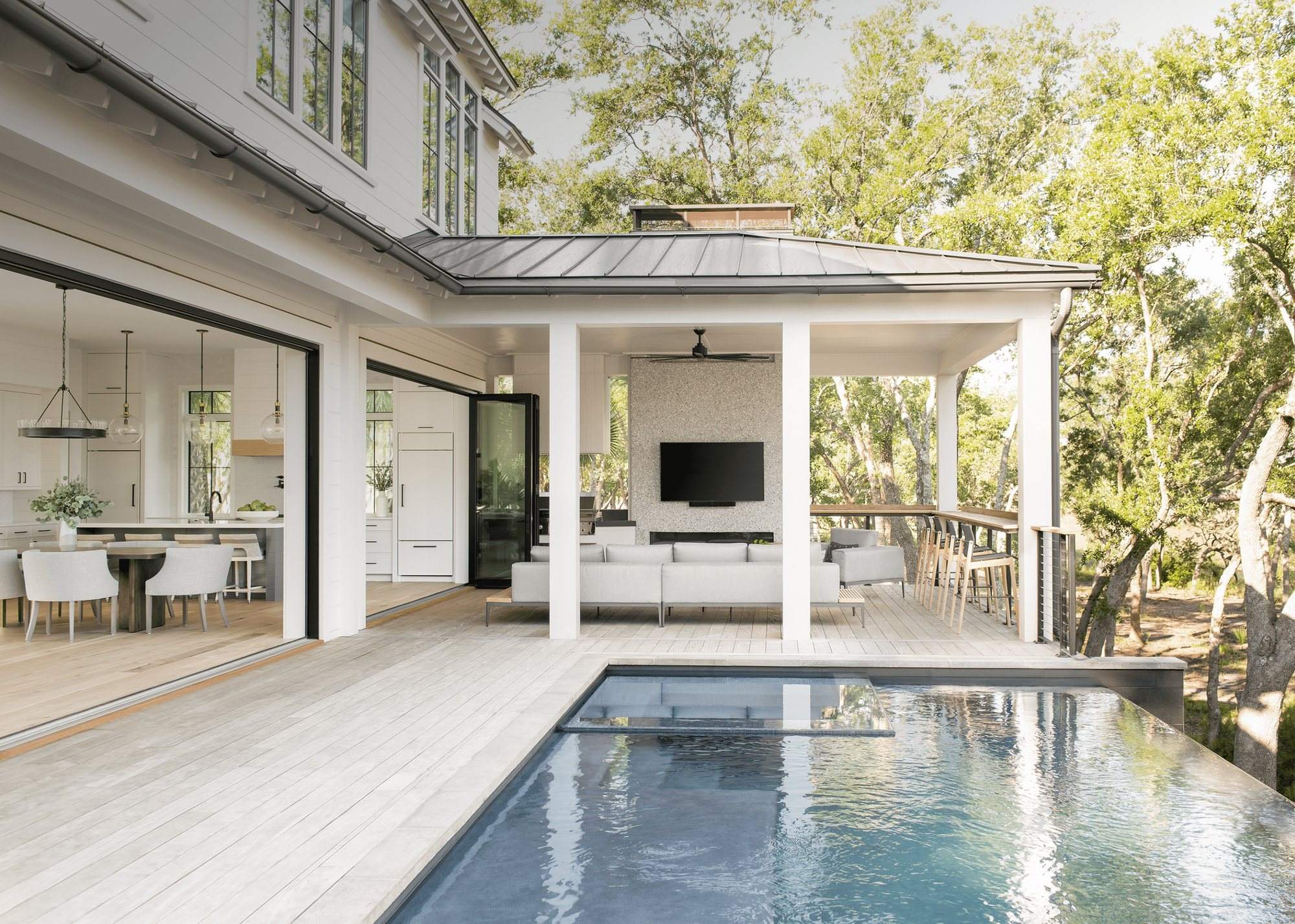 Euro-Wall Vista Fold folding glass doors fully open from a living room to a covered porch and swimming pool