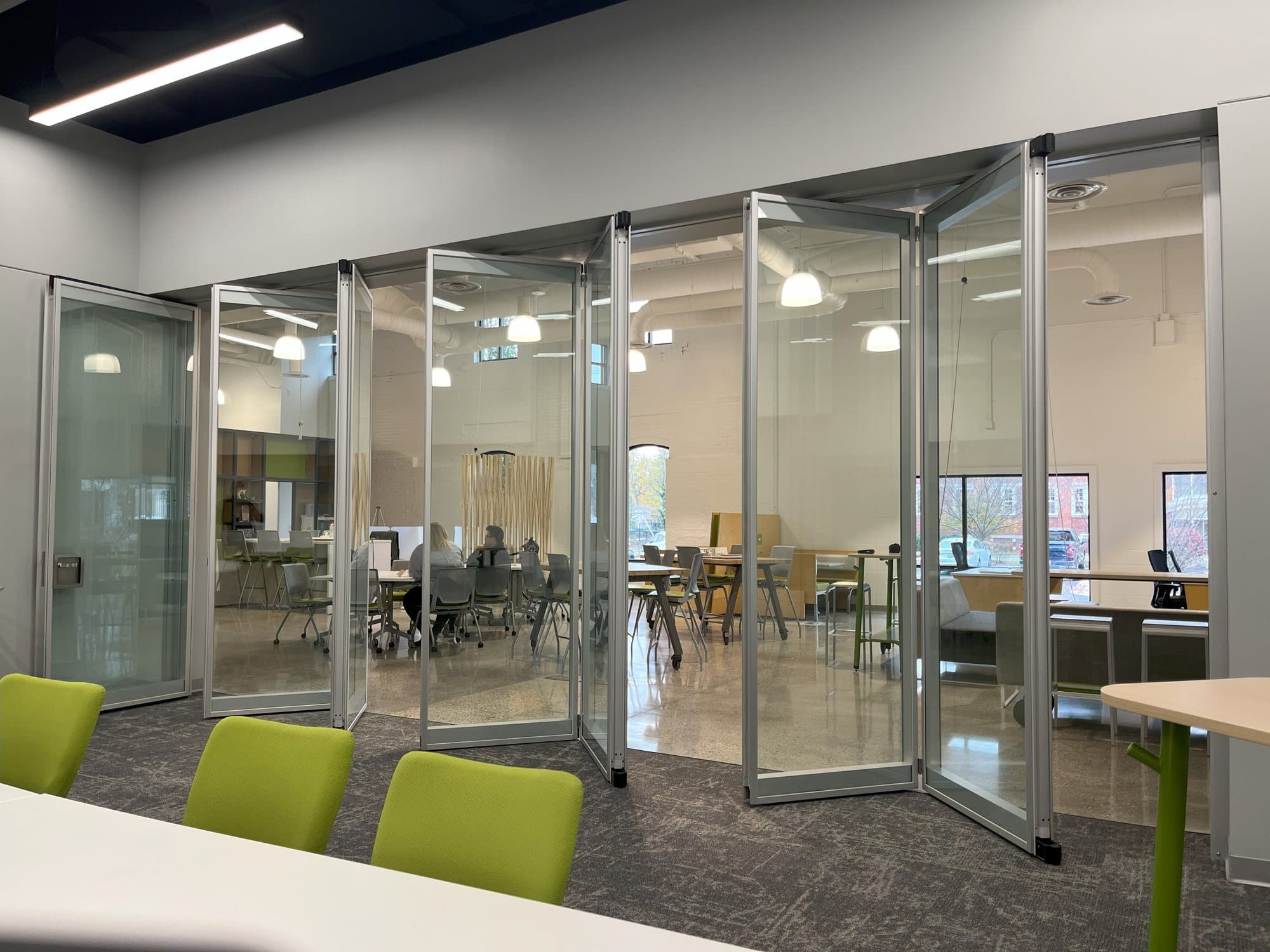 Acousti-Clear paired glass panels folding on their hinges, seen from inside the meeting room at GMB Architecture's GRR Hub