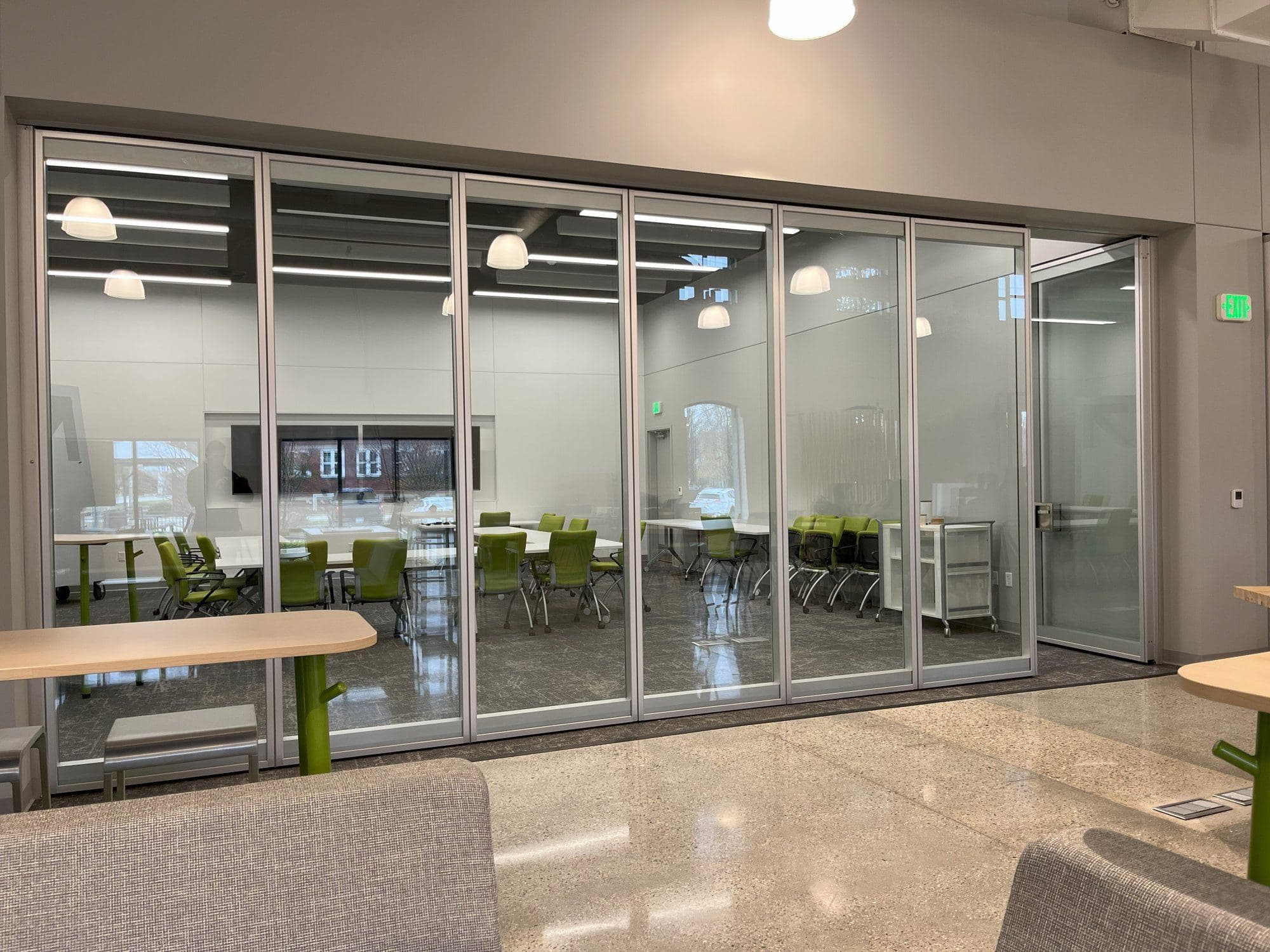 Acousti-Clear paired panel glass wall nearly closed at GMB Architecture's GRR Hub, with the pivot door panel at the end of the run
