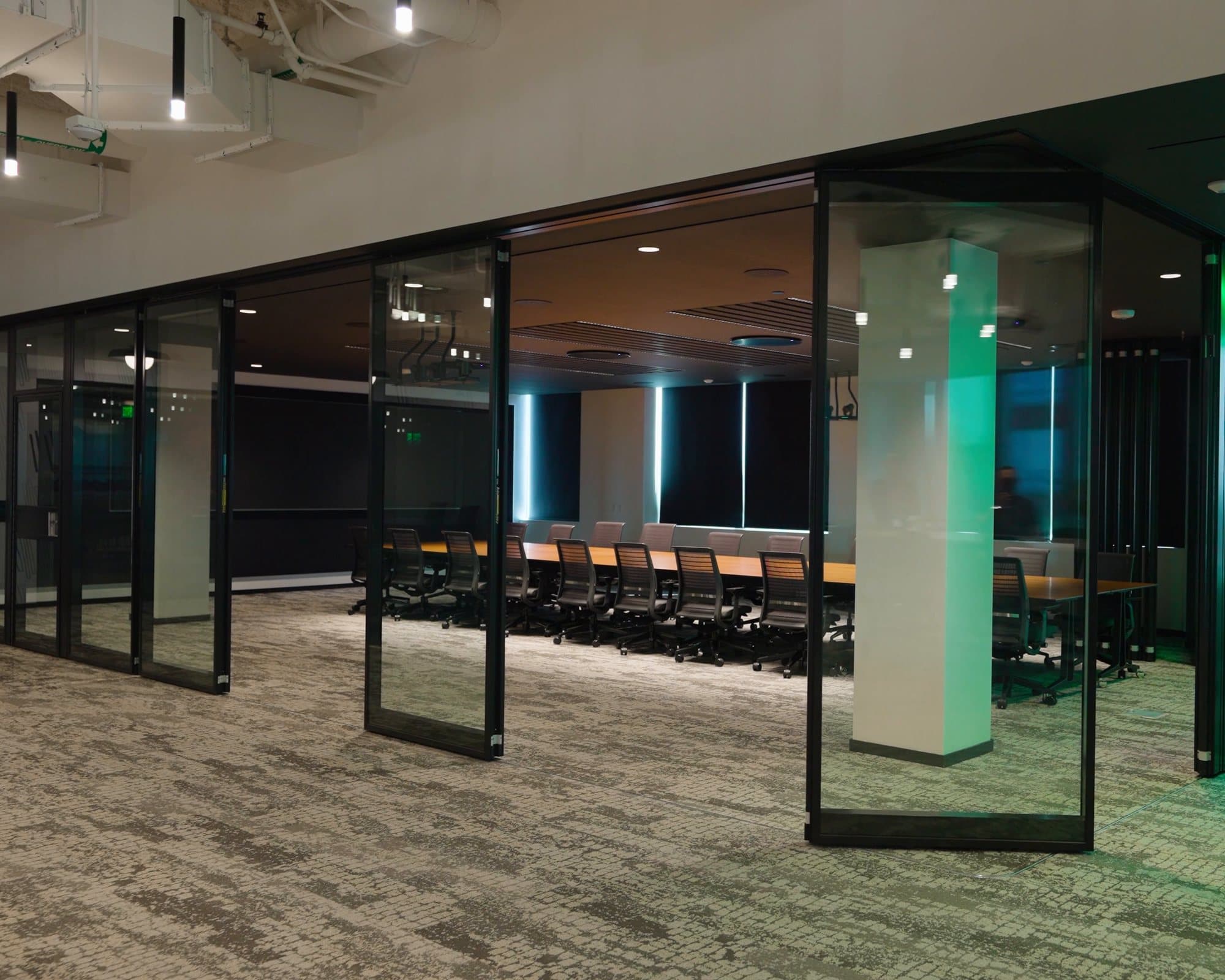 Acousti-Clear glass panels on Modernfold ComfortDrive driving out of the stack on their own to close off a conference room