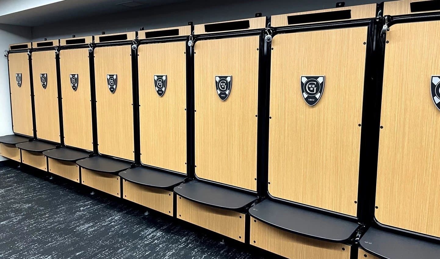Row of GearGrid GridIron team lockers with wood laminate doors in a locker room