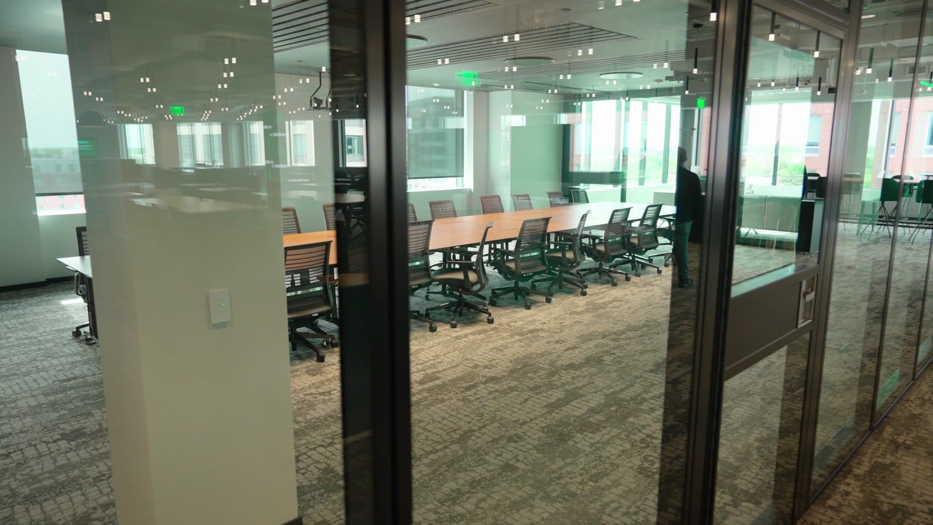 Acousti-Clear glass operable wall panels beside a long boardroom table and a white column