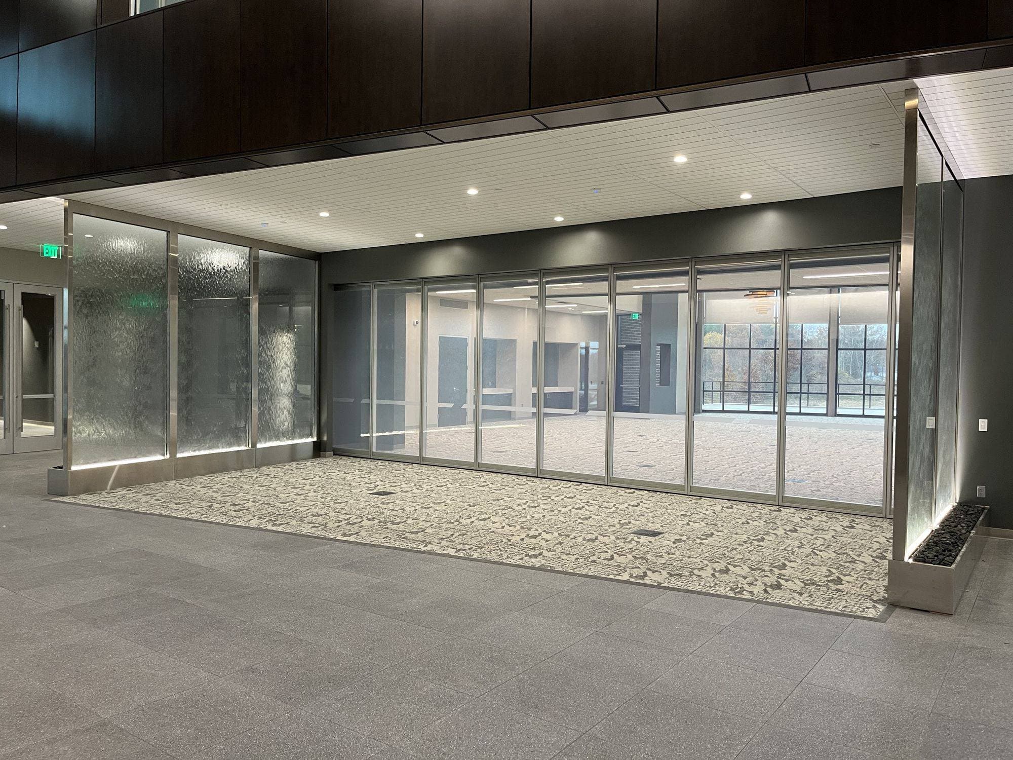Closed Acousti-Clear glass wall at Advia Credit Union with the panels clear, showing the room and windows behind