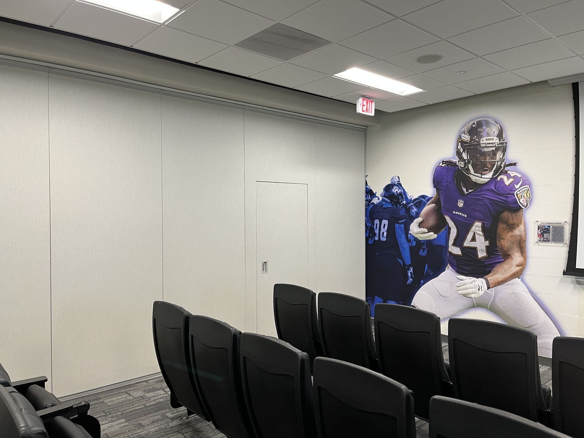 Closed folding panel partition meeting the mural wall in the GVSU film room, with theater seating in front