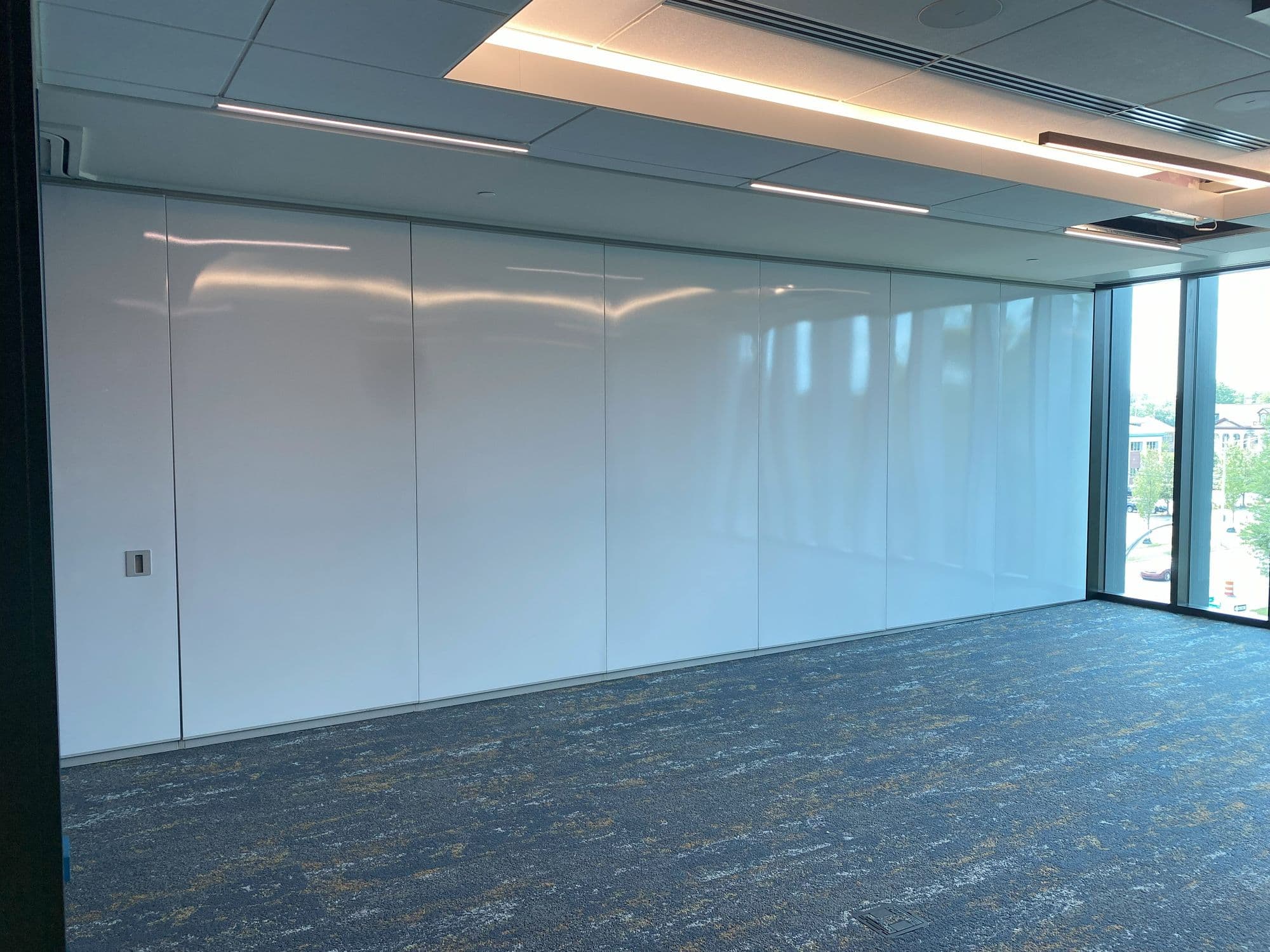 Row of closed white markerboard Acousti-Seal panels spanning the room at Michigan Realtors