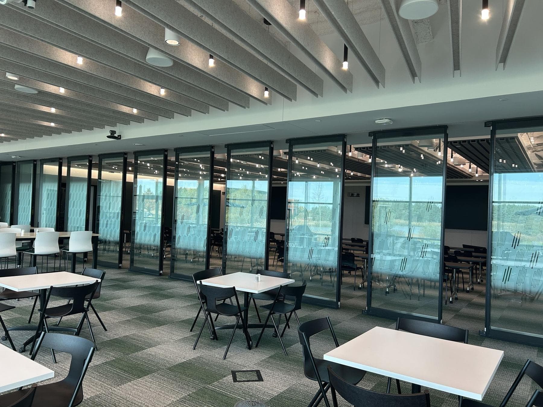 Acousti-Clear glass wall seen from the side with cafe tables and chairs