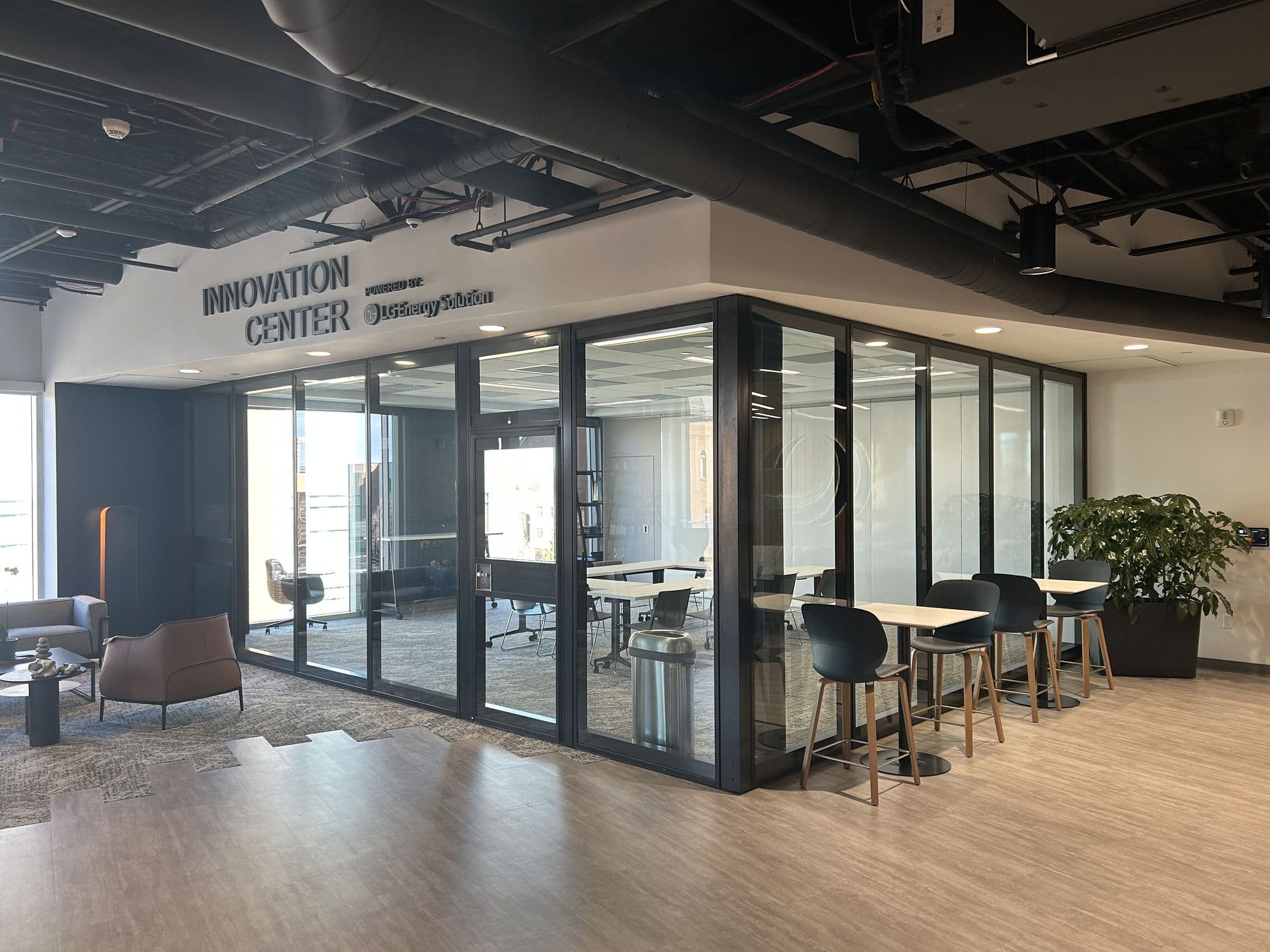 Closed Acousti-Clear glass wall with black frames beside high-top tables at the West Coast Chamber of Commerce