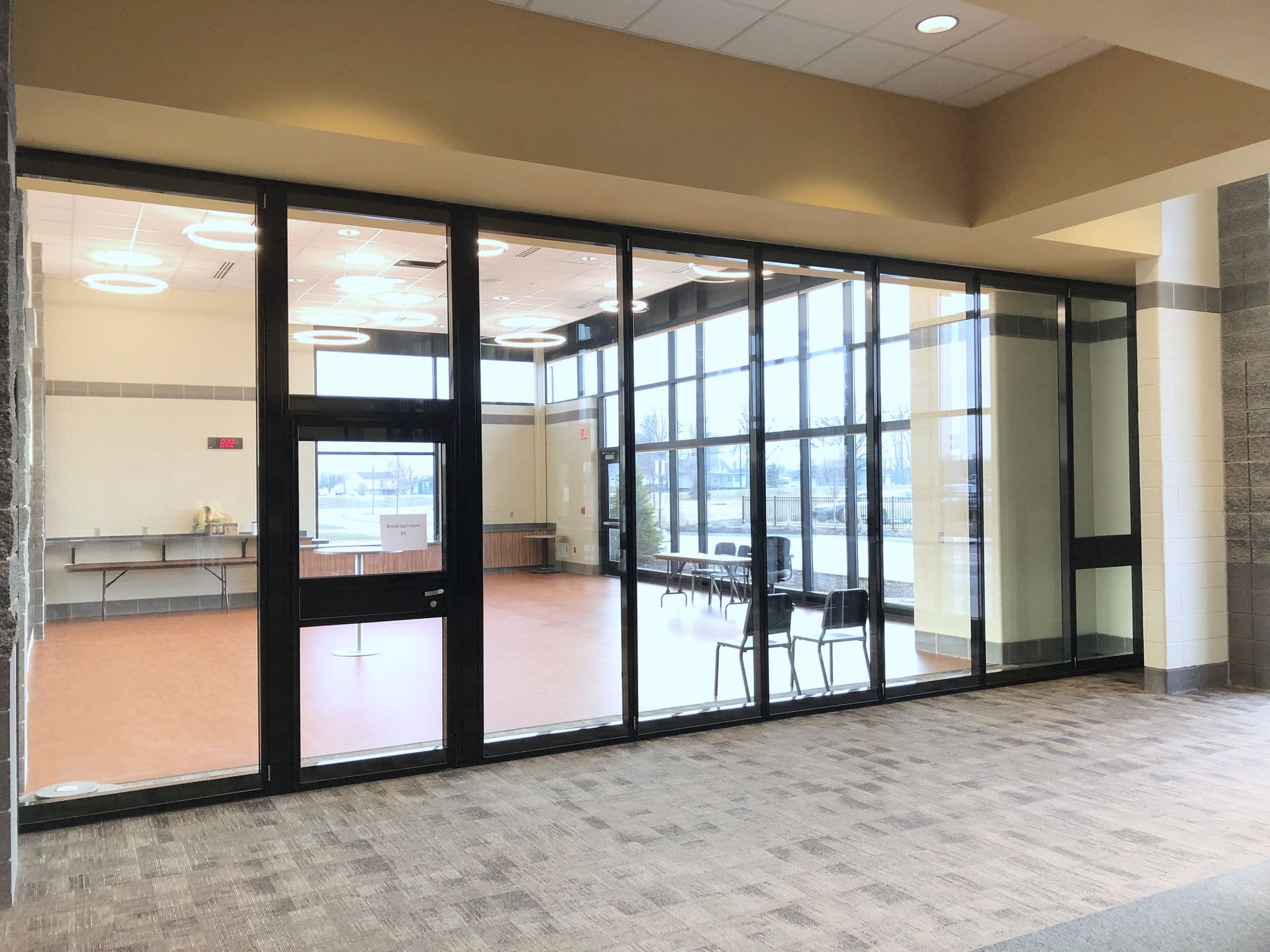Acousti-Clear glass wall with a pass door in the panel run at Zeeland East High School
