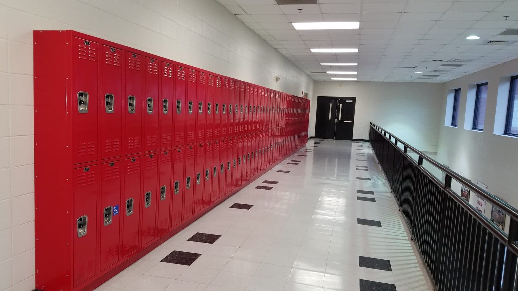Red metal school lockers lining a school hallway