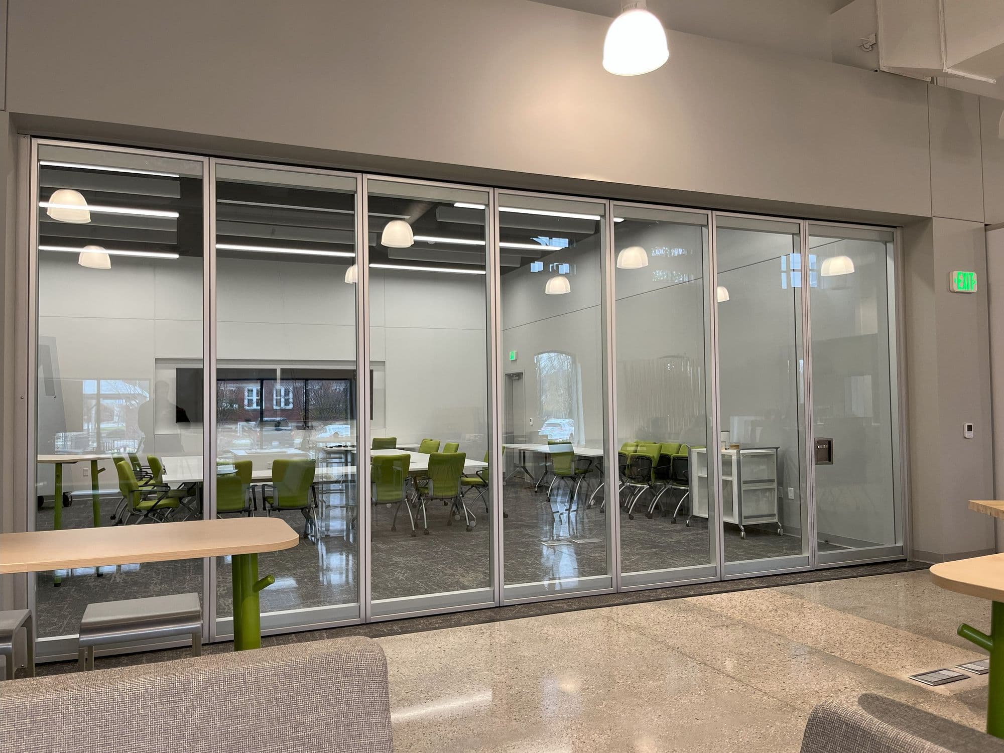 Closed Modernfold Acousti-Clear glass wall with clear anodized frames at the GMB Grand Rapids Learning Hub