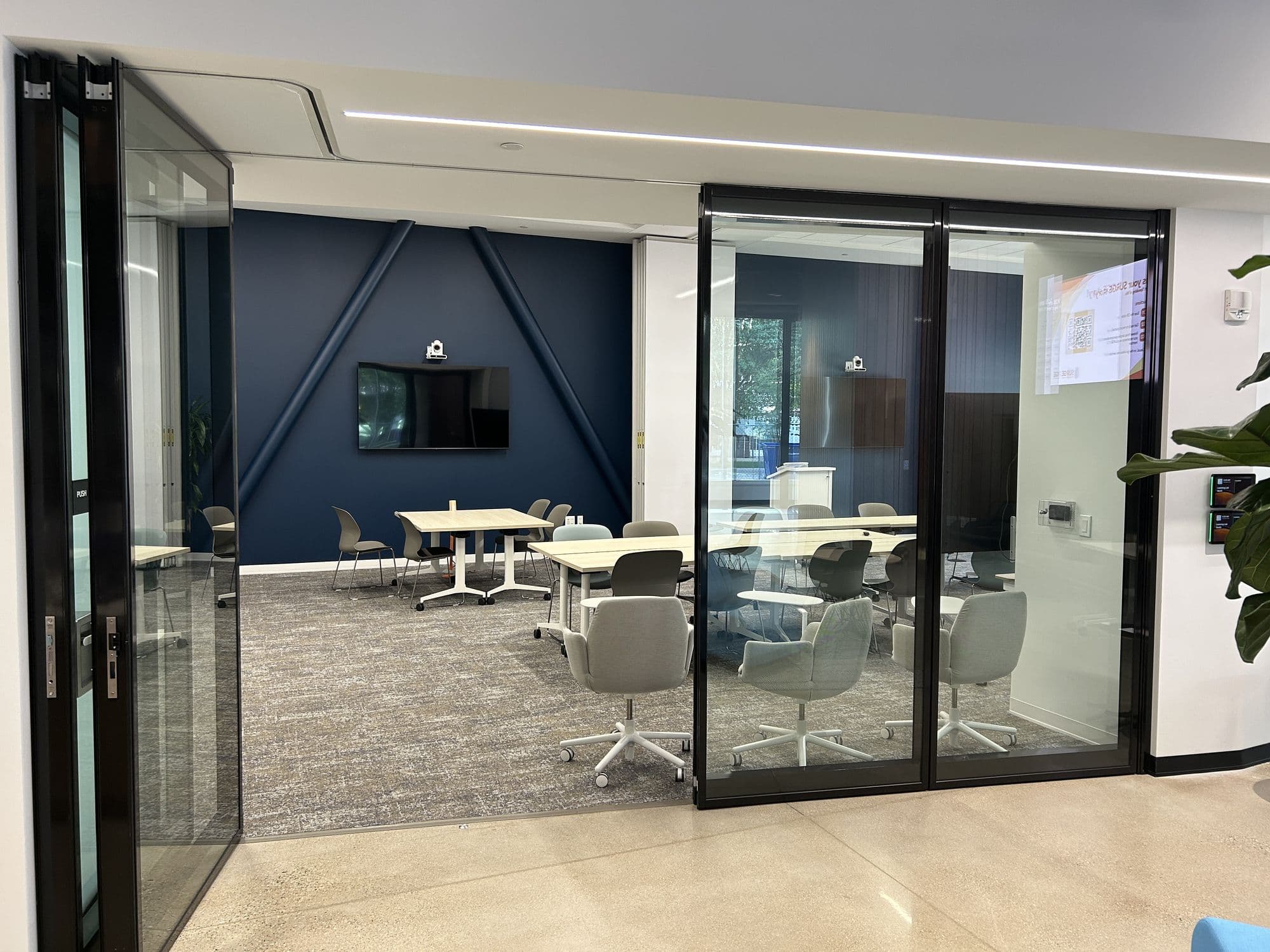 Folding glass operable wall partly open, with panels folded at one end of the track