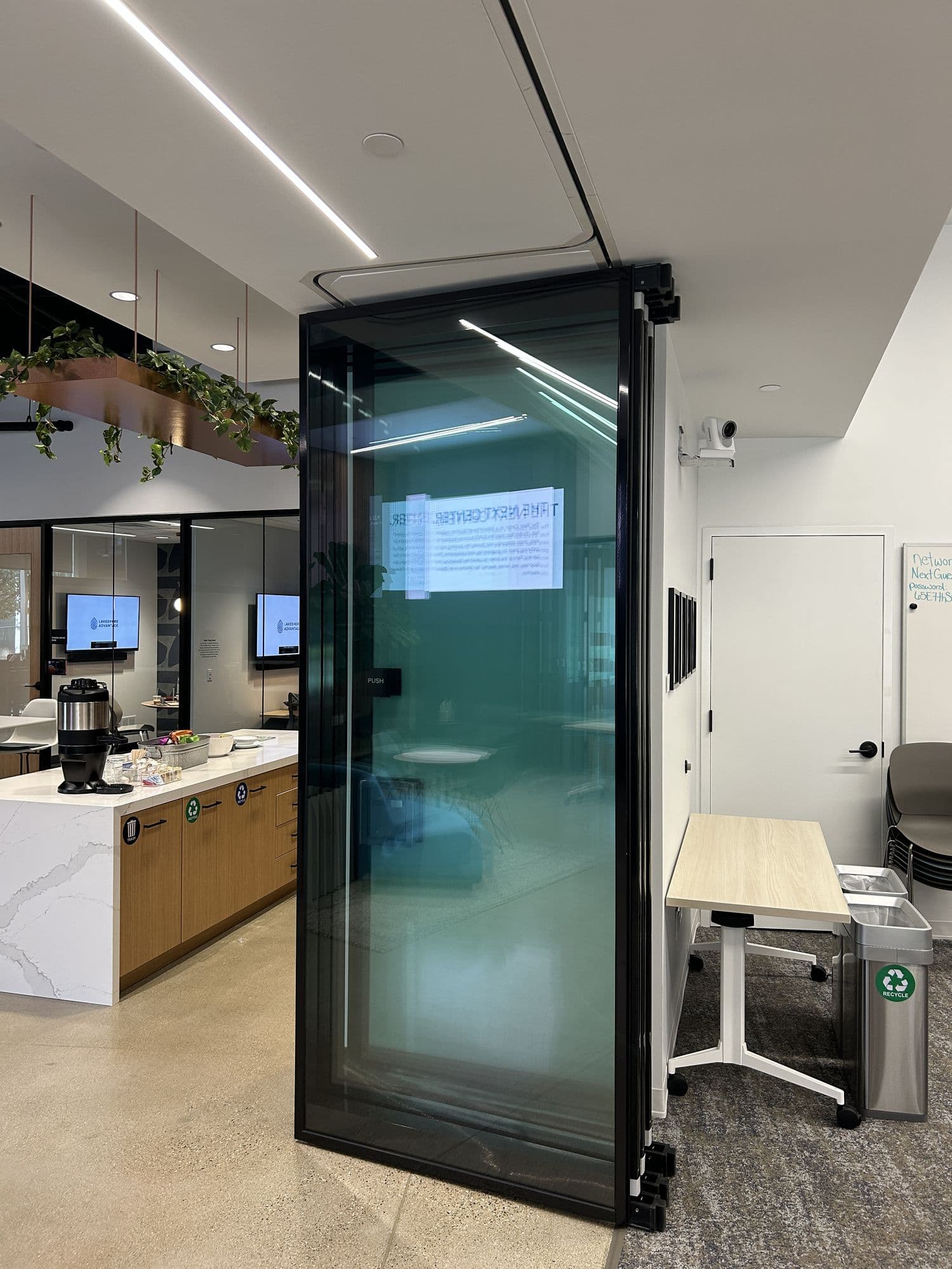 Tall stack of Acousti-Clear glass panels with black frames beside a counter at Lakeshore Advantage