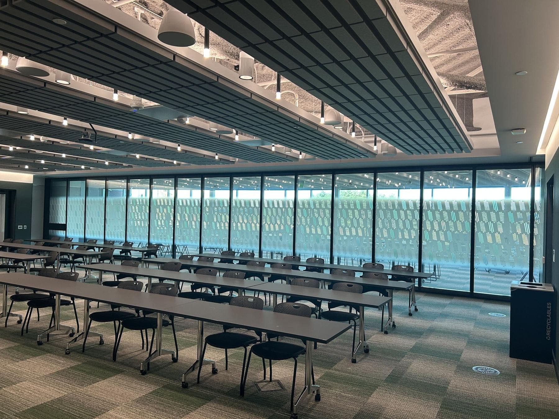Closed Acousti-Clear glass operable wall along the far side of a large training room, with windows beyond