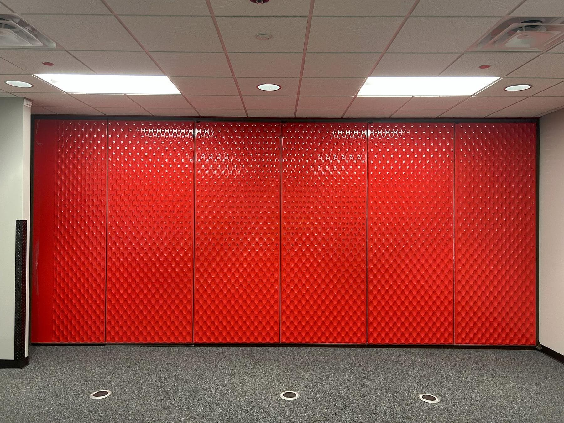 Closed Modernfold Acousti-Seal folding panel partition in a red designer line finish across a room at Switch in Grand Rapids