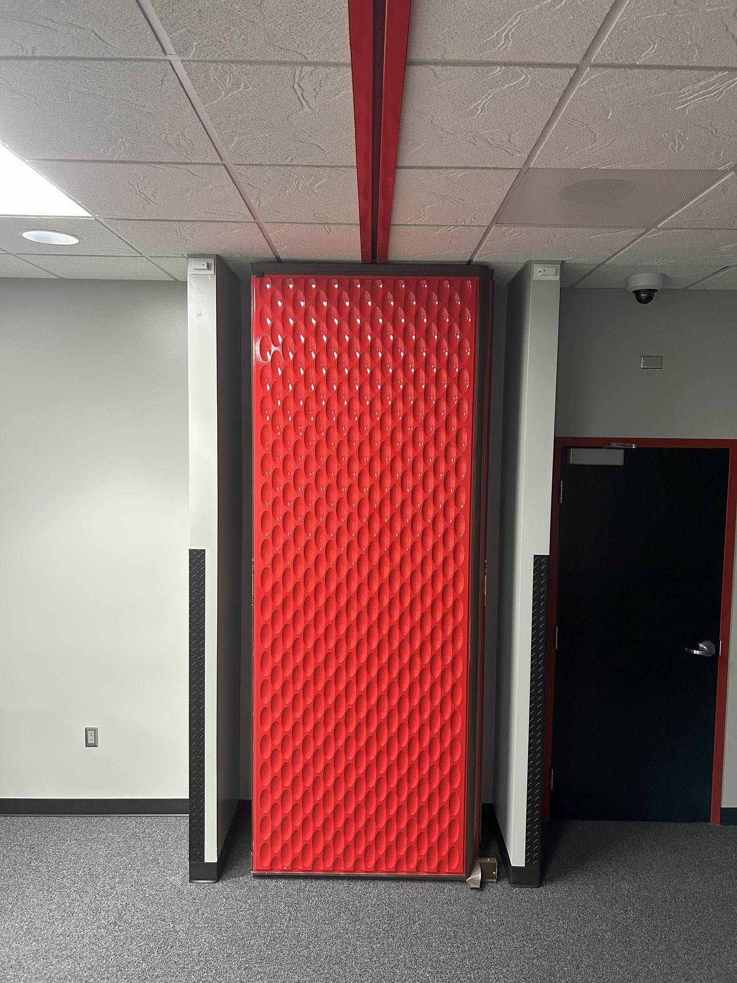 Red Acousti-Seal panels stacked at the wall beneath the ceiling track at Switch